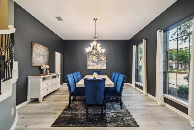 dining space with baseboards, visible vents, an inviting chandelier, and light wood-style flooring
