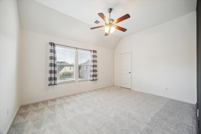 unfurnished room with visible vents, light carpet, baseboards, ceiling fan, and vaulted ceiling