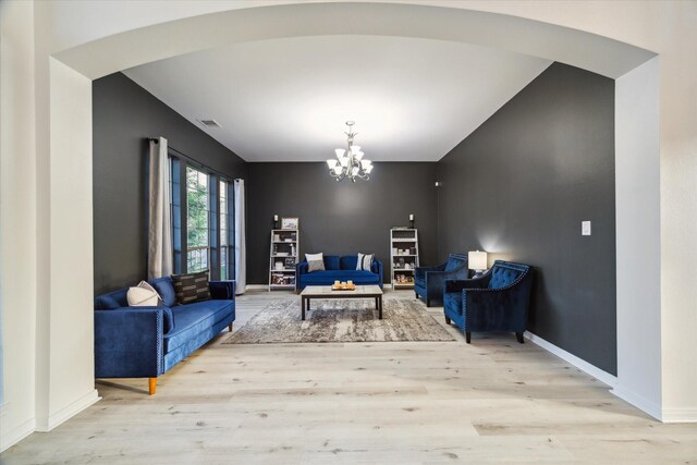 interior space with light wood-style floors, baseboards, visible vents, and a notable chandelier
