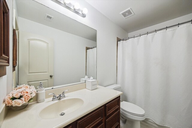 full bathroom featuring visible vents, toilet, and vanity