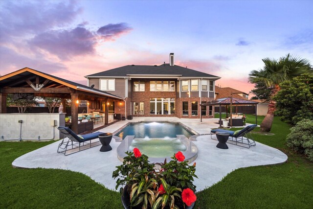 back of property featuring a yard, a gazebo, an outdoor hangout area, and a patio area