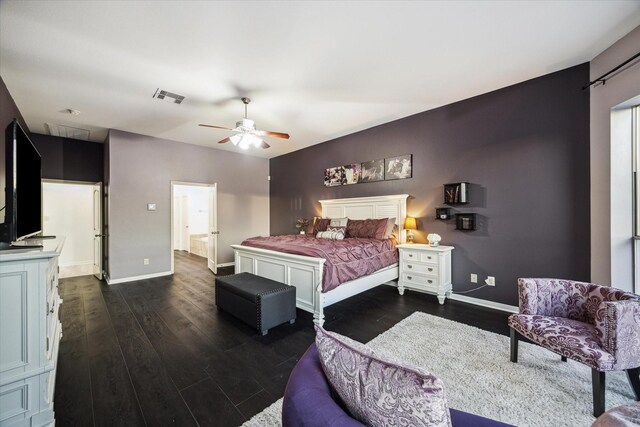 bedroom with ceiling fan, dark wood-style flooring, visible vents, baseboards, and ensuite bath