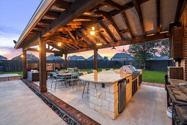 view of patio / terrace with grilling area, a bar, a fenced backyard, and area for grilling