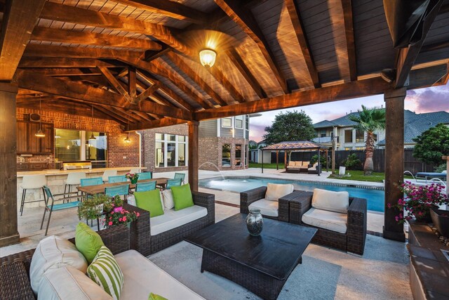 view of patio / terrace featuring fence, an outdoor living space, a fenced in pool, a gazebo, and a bar