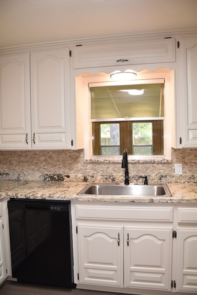 kitchen featuring tasteful backsplash, dishwasher, white cabinetry, and a sink