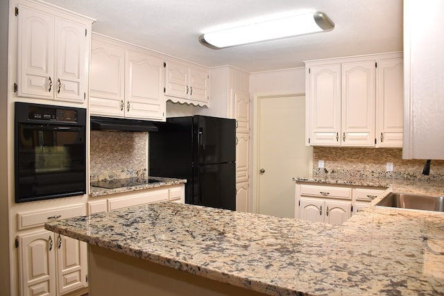 kitchen featuring backsplash, under cabinet range hood, a sink, and black appliances