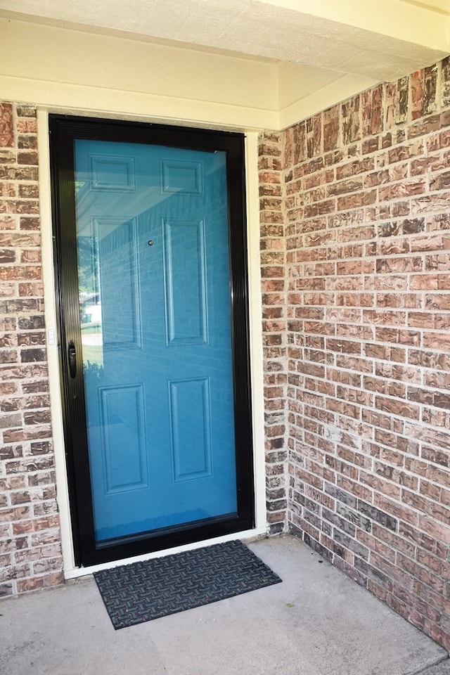 view of exterior entry featuring brick siding