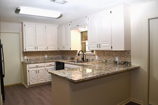 kitchen with a peninsula, decorative backsplash, and a sink