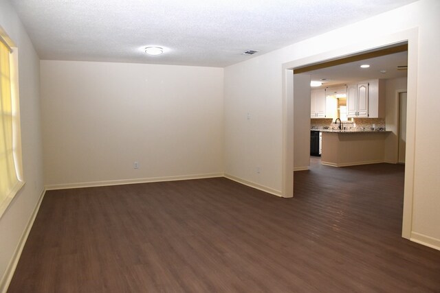 unfurnished room with baseboards, visible vents, and dark wood-type flooring