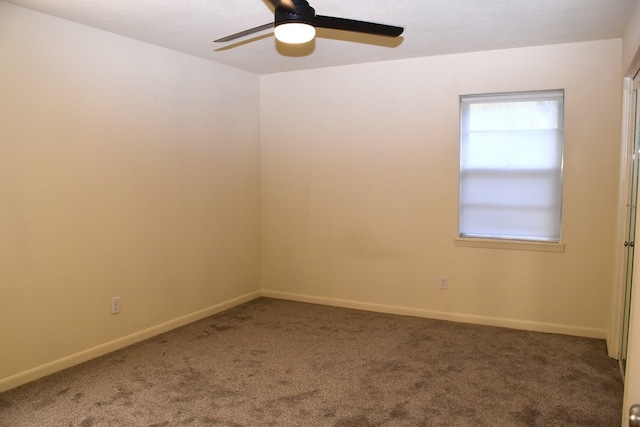 carpeted empty room featuring baseboards and ceiling fan