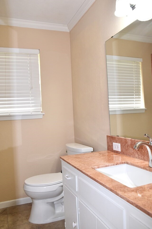 bathroom featuring tile patterned floors, crown molding, vanity, and toilet