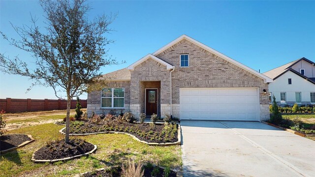 view of front of home with an attached garage, fence, stone siding, and driveway