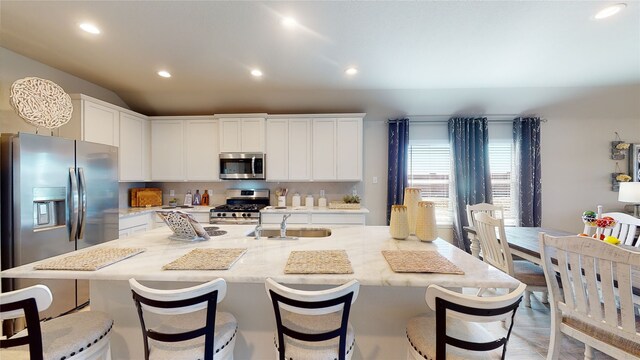kitchen with recessed lighting, white cabinets, a sink, a kitchen island with sink, and appliances with stainless steel finishes