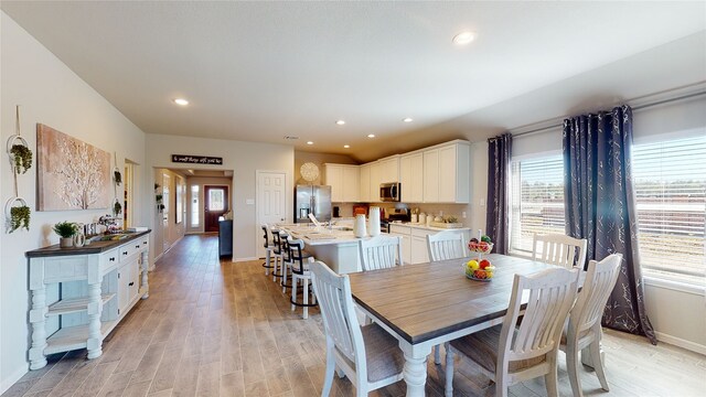 dining room featuring recessed lighting, light wood-style floors, and baseboards