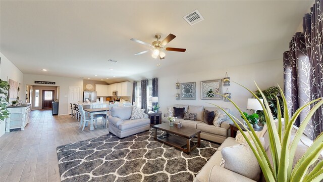 living area featuring recessed lighting, a ceiling fan, visible vents, and light wood-style flooring