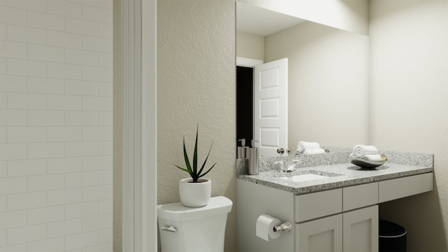 bathroom featuring vanity, a textured wall, and toilet