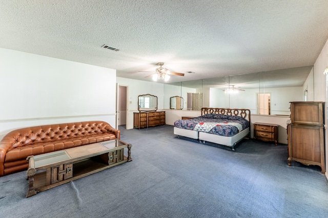 bedroom with carpet, visible vents, and a textured ceiling