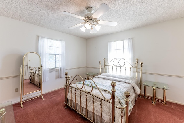 carpeted bedroom with a textured ceiling, baseboards, and multiple windows