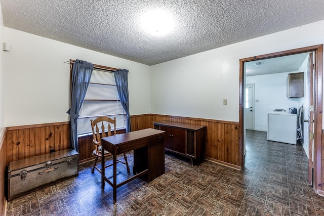 home office with wood walls, a textured ceiling, washer / dryer, and a wainscoted wall