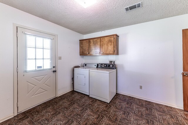 washroom featuring cabinet space, washing machine and dryer, baseboards, visible vents, and a textured ceiling