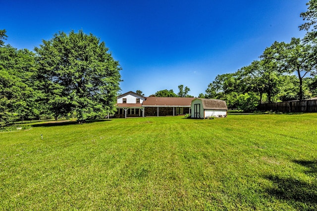 view of yard featuring an outdoor structure, a storage shed, and fence