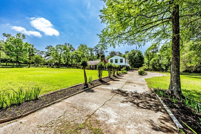 exterior space with concrete driveway and a lawn