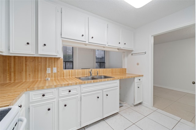 13742 Hollowgreen Dr Unit 604, Houston, TX 77082 - kitchen with white cabinets, a sink, light countertops, light tile patterned flooring, and stove