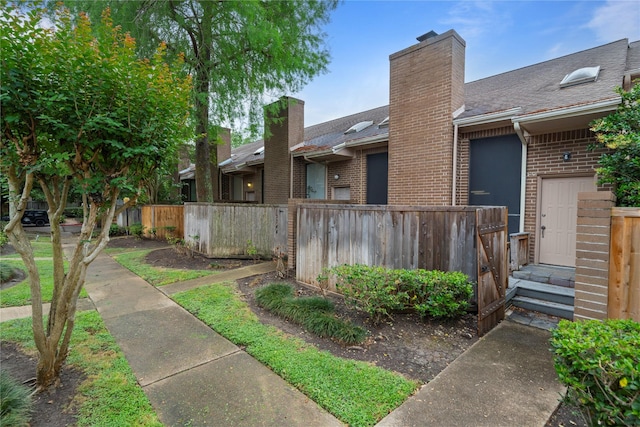 13742 Hollowgreen Dr Unit 604, Houston, TX 77082 - back of property with fence, a chimney, brick siding, and roof with shingles