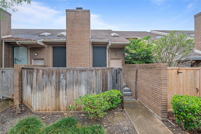 13742 Hollowgreen Dr Unit 604, Houston, TX 77082 - view of side of home featuring a chimney, brick siding, and a fenced backyard