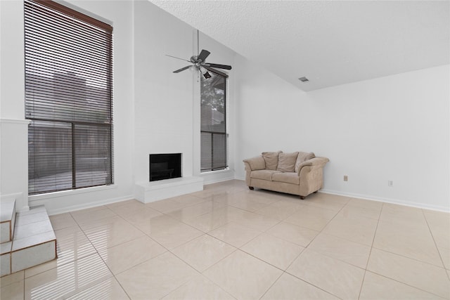 13742 Hollowgreen Dr Unit 604, Houston, TX 77082 - living area with light tile patterned floors, a ceiling fan, a large fireplace, baseboards, and a textured ceiling