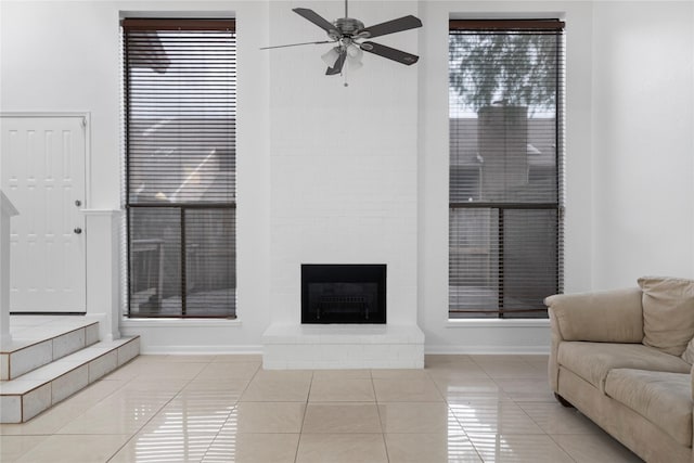 13742 Hollowgreen Dr Unit 604, Houston, TX 77082 - living area featuring a ceiling fan, tile patterned flooring, a brick fireplace, and baseboards