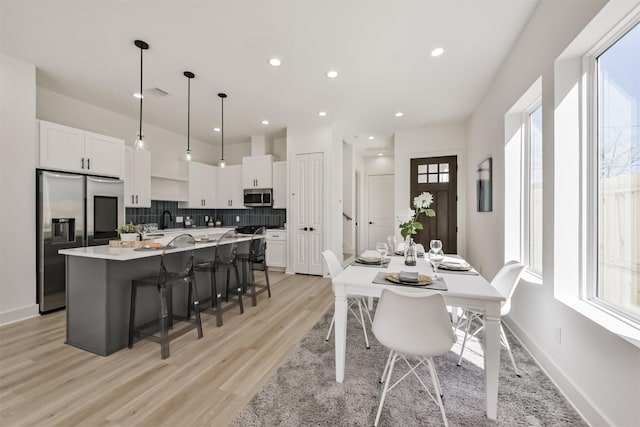 dining room with recessed lighting, baseboards, light wood-type flooring, and visible vents