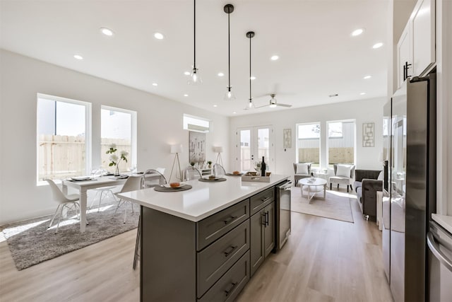 kitchen with light countertops, a center island, recessed lighting, open floor plan, and light wood-type flooring