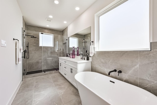 full bathroom featuring visible vents, double vanity, recessed lighting, a freestanding bath, and a stall shower