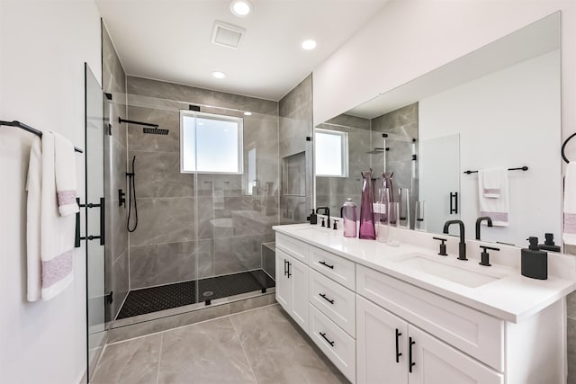 bathroom with a sink, double vanity, marble finish floor, recessed lighting, and a stall shower