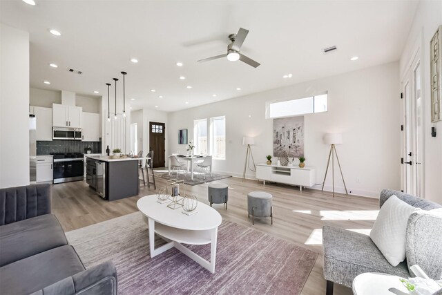 living area with recessed lighting, ceiling fan, visible vents, and light wood finished floors