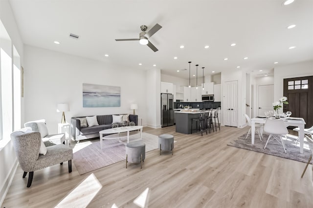 living area with recessed lighting, a ceiling fan, light wood finished floors, and visible vents
