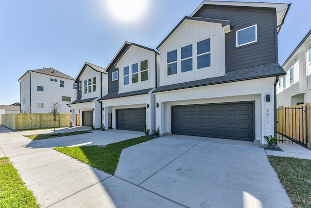multi unit property with an attached garage, board and batten siding, fence, and concrete driveway