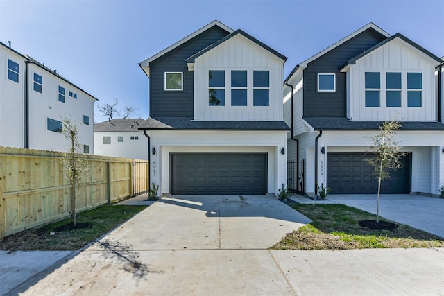 view of front facade with board and batten siding, fence, concrete driveway, and a garage