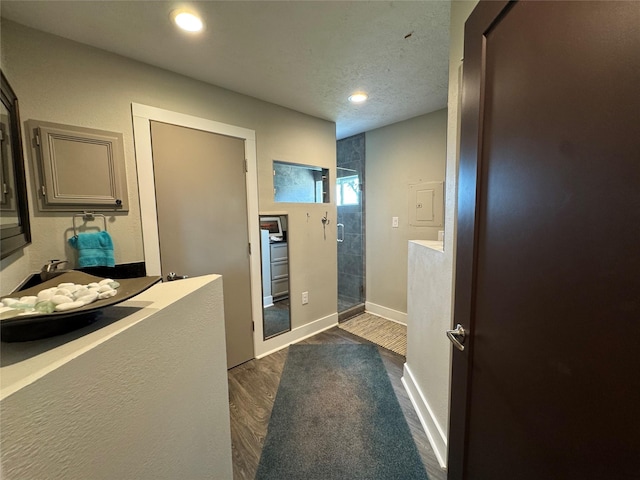 full bath featuring baseboards, wood finished floors, a stall shower, and recessed lighting