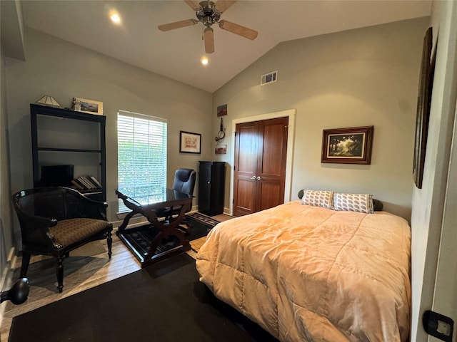 bedroom featuring lofted ceiling, a closet, dark wood finished floors, ceiling fan, and visible vents