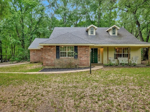 view of front of property featuring roof with shingles, a porch, and a front lawn