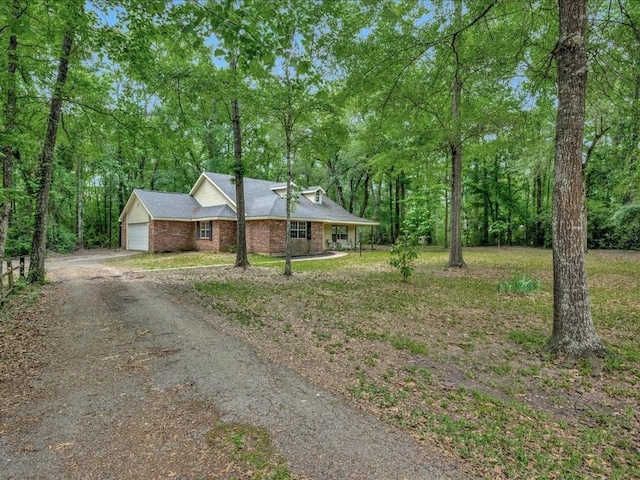 view of front of home with a garage, brick siding, and driveway