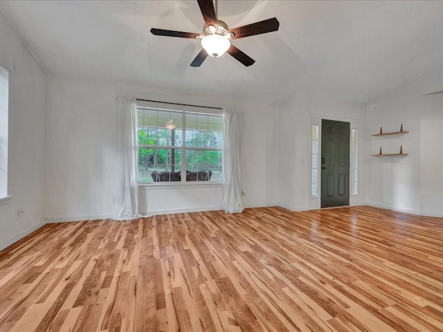 empty room with ceiling fan, wood finished floors, and baseboards