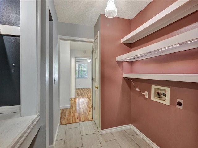 washroom featuring laundry area, electric dryer hookup, washer hookup, baseboards, and a textured ceiling
