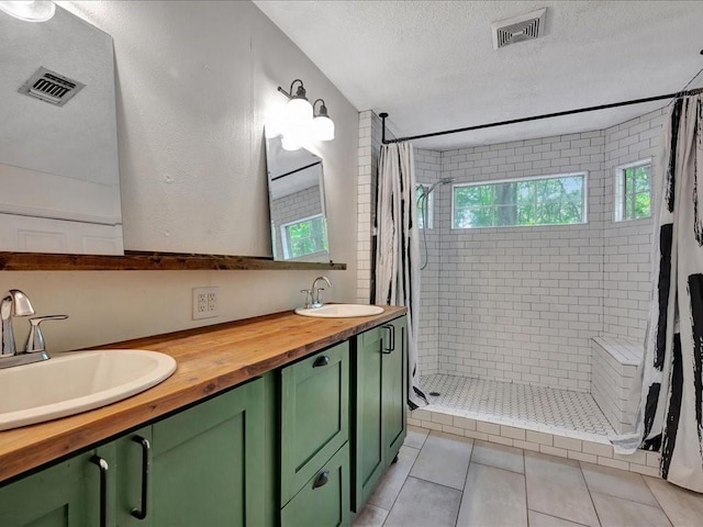 bathroom featuring visible vents, a shower stall, and a sink