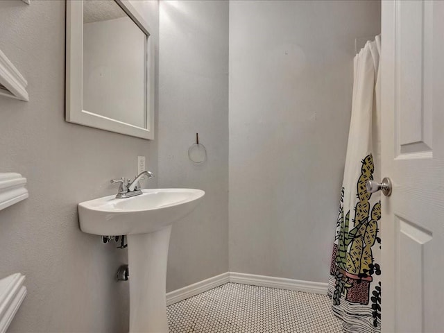 bathroom featuring tile patterned flooring, baseboards, and a shower with shower curtain