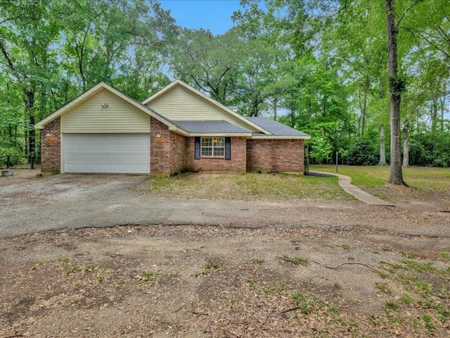 ranch-style home with aphalt driveway, brick siding, and a garage