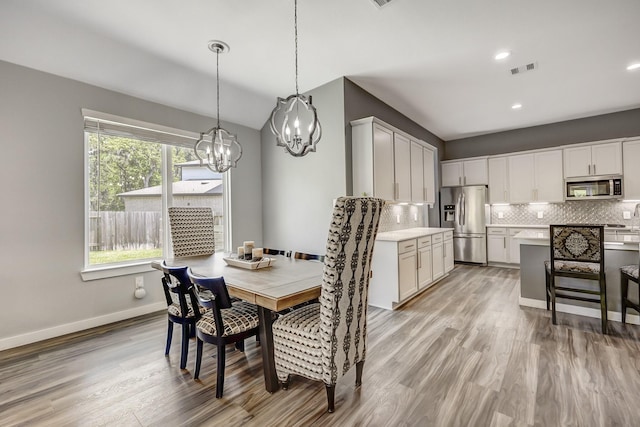 14302 Winema View Ln, Conroe, TX 77384 - dining area with a chandelier, light wood-style floors, baseboards, recessed lighting, and lofted ceiling