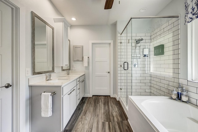 14302 Winema View Ln, Conroe, TX 77384 - bathroom with a stall shower, a garden tub, wood finished floors, double vanity, and a ceiling fan